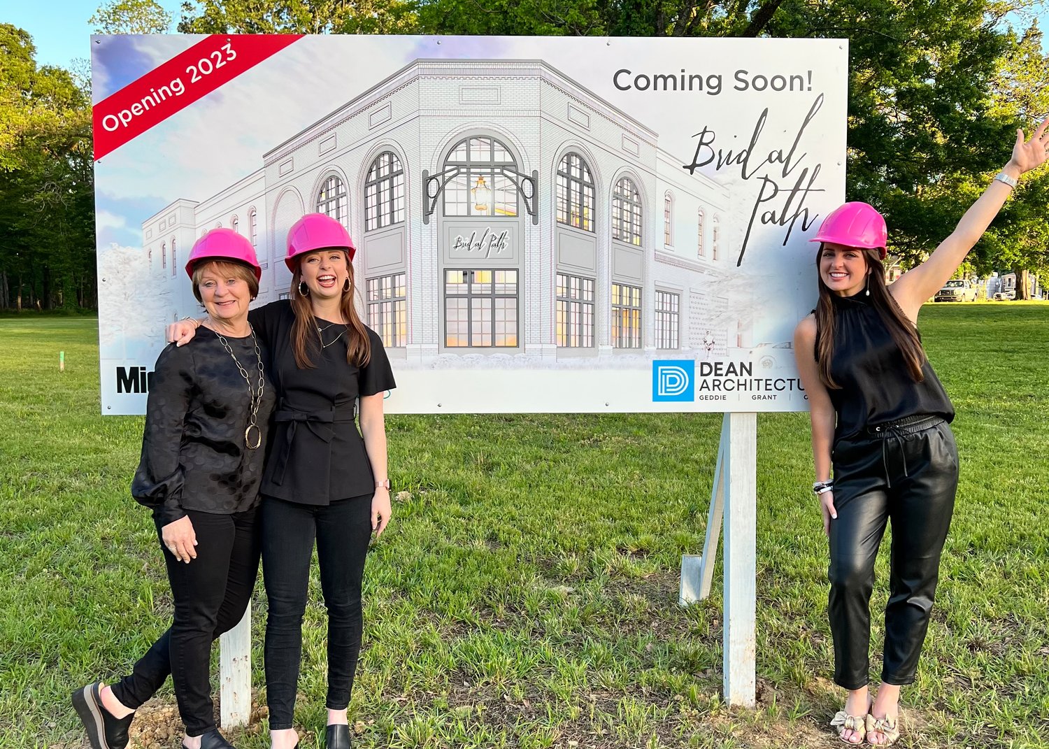 Owners of Bridal Path pose in front of the sign advertising the new location of the bridal shop on Main Street in Madison. Pictured, from left: co-owners Janie Jarvis, Audrey McCarty and Amelia Jarvis.